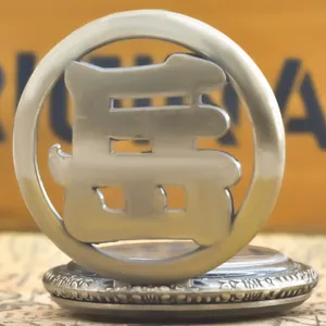 Detail view of a vintage silver pocket watch with a hollowed Chinese character design