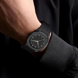 Detalle de reloj de cuarzo octogonal negro con números arábigo-índicos en la esfera