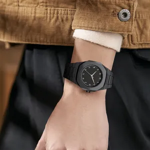 Primer plano de un reloj de hombre negro minimalista con números arábigos en la muñeca