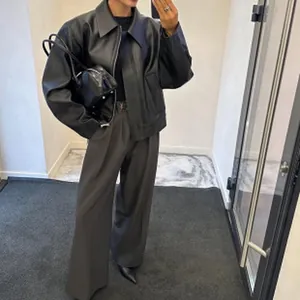 Dettaglio di un'elegante giacca in ecopelle nera con maniche ampie e vestibilità comoda.