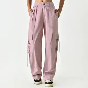 Close-up of pink cargo pants for women featuring multiple pockets and side straps.