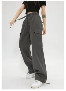 Vista laterale dei pantaloni cargo grigio scuro a gamba larga con grandi tasche a patta