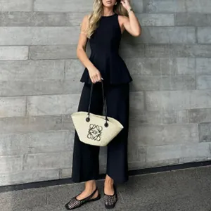 Elegante top peplo nero senza maniche e pantaloni a gamba larga per un look sofisticato