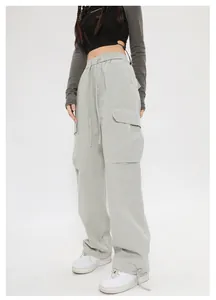 Vista dettagliata dei pantaloni cargo retrò verde salvia con ampie tasche e coulisse.