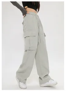 Vista laterale di pantaloni cargo oversize verde salvia con tasche a pattina.