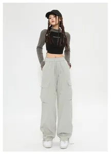 Dettaglio dei pantaloni cargo vintage unisex in grigio salvia stile street largo.