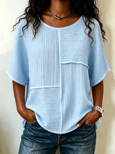 Nahaufnahme eines hellblauen Patchwork-Oberteils aus Crinkle-Stoff für Damenmode.