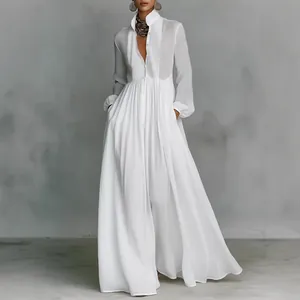 Detail of white long-sleeved maxi dress featuring elegant pleated skirt and button-up front.