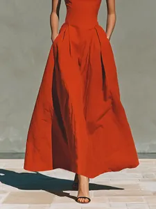 Detailed view of red pleated maxi dress with functional side pockets and linen texture