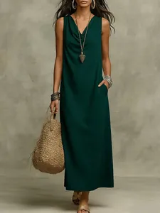Vista detallada del vestido largo verde oscuro con cuello drapeado y bolsillos útiles