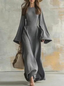 Gros plan sur une robe longue plissée grise avec manches cloche et taille ajustée