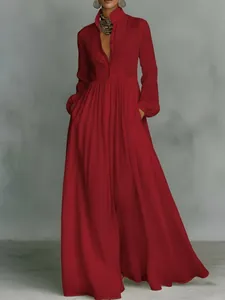 Elegant red pleated long-sleeved maxi dress with high collar and flowing silhouette.
