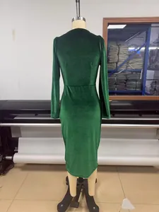 Back view of an elegant dark green velvet long-sleeve bodycon dress on a mannequin stand