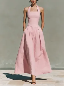 Elegant pink halter-neck maxi dress featuring pleated waist and functional side pockets