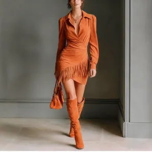 Detailed view of women's western style suede wrap dress featuring fringe hem detail