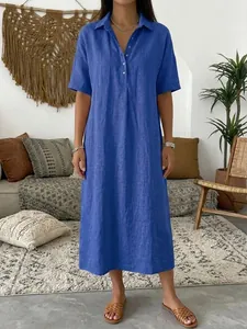 Women's casual blue linen short-sleeved polo dress shown in a cozy home setting