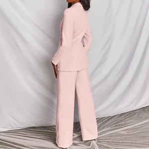 Vista posteriore di elegante tailleur rosa due pezzi con blazer e pantaloni larghi
