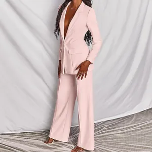 Dettaglio di un elegante tailleur rosa da donna con blazer e pantaloni a gamba larga classici.