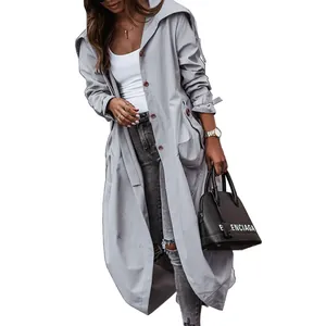Detail shot of a women's long grey trench coat with a large lapel and button closure.