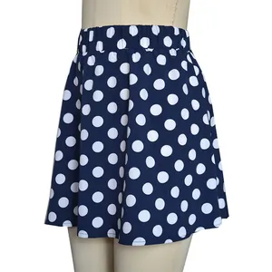 Détail de la mini-jupe trapèze bleu marine avec un motif à gros pois blancs vif.