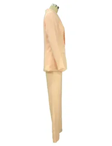 Vista laterale di un completo da donna color pesca con blazer e pantaloni dritti
