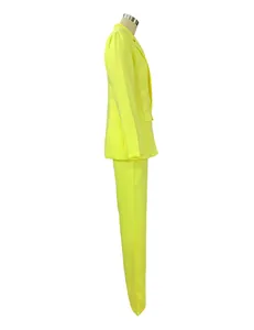 Profilo laterale di un blazer da donna giallo neon con pantaloni dritti abbinati.