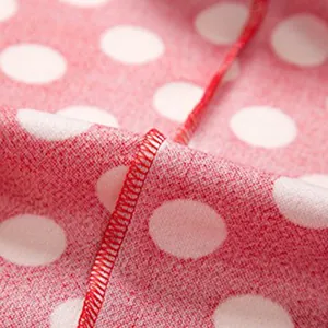 Vue macro montrant les coutures de haute qualité sur un tissu rouge à pois blancs