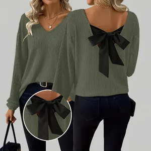 Detalle de jersey acanalado verde oliva para mujer con un gran lazo negro en la espalda