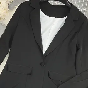 Primo piano di un blazer nero professionale a maniche lunghe con rever a lancia e fodera bianca