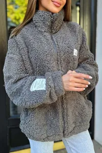 Detail view of a women's grey fuzzy sherpa fleece jacket with a high collar and zipper.