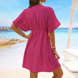 Fuchsia ice silk beach cover-up dress shown from the back against a sunny beach background.