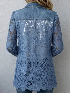 Dettaglio del patchwork in pizzo floreale sul retro della giacca di jeans blu.