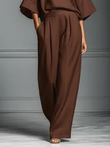 Detail of elegant brown linen two-piece set with wide-leg pants and flared sleeves