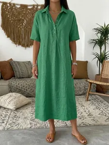 Elegant green linen maxi dress with polo collar and short sleeves in a boho home setting