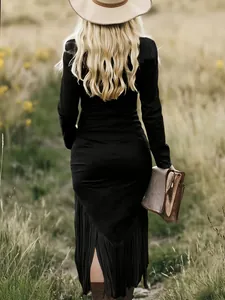 Back view of a black slim-fit dress with stylish fringe hem detail in a meadow