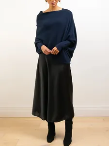 Close-up detail of the navy blue knit pullover featuring batwing sleeves and satin skirt