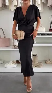 Elegante abito lungo nero con scollo a V e dettaglio a incrocio per un look raffinato.