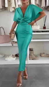 Dettaglio di un elegante abito lungo in raso verde con scollo a V e nodo intrecciato.