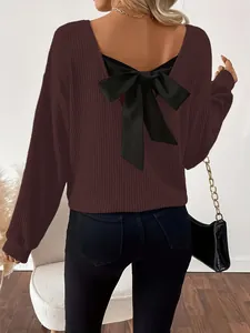 Vista trasera de un suéter burdeos con cuello en V y un gran lazo negro decorativo