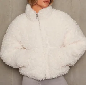 Gros plan d'une veste courte en laine d'agneau blanche et douce avec fermeture éclair