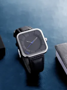 Gros plan sur la montre à quartz TOMI avec cadran noir mat et trotteuse bleue distinctive