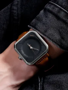 Gros plan de la montre à quartz carrée minimaliste TOMI avec bracelet en cuir brun.