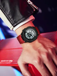 Gros plan d'une montre numérique de sport pour hommes avec bracelet rouge et rétroéclairage LED