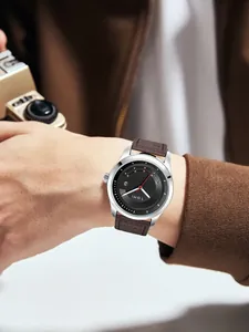 Nahaufnahme der TOMI Modeuhr mit braunem Lederarmband und schwarzem Zifferblatt am Handgelenk