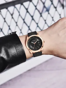Nahaufnahme der TOMI Modeuhr in Roségold mit schwarzem Lederarmband am Handgelenk