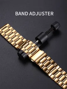 Gros plan d'un outil de réglage de bracelet noir sur un bracelet de montre en acier doré