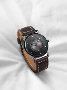 Primo piano dell'orologio TOMI minimalista con datario e cinturino in pelle marrone