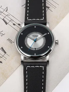 Dettaglio ravvicinato dell'orologio minimalista TOMI con quadrante cavo e cinturino in pelle
