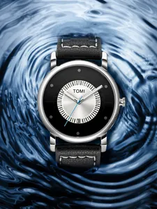 Primo piano dell'orologio minimalista TOMI con cinturino in pelle nera e datario.