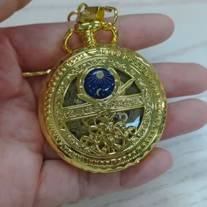 Gros plan détaillé d'une montre à gousset mécanique dorée avec motifs de soleil et lune.
